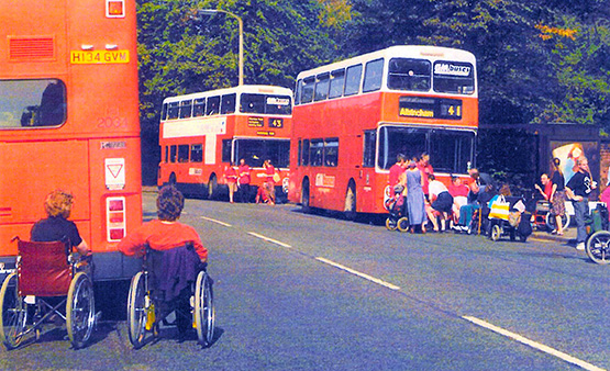 People in wheelchairs waiting for a bus