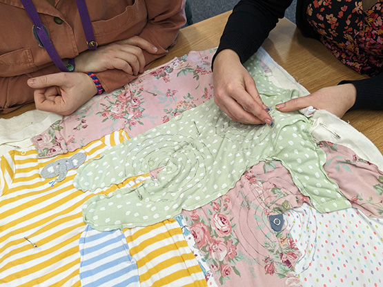 people stitching a quilt 