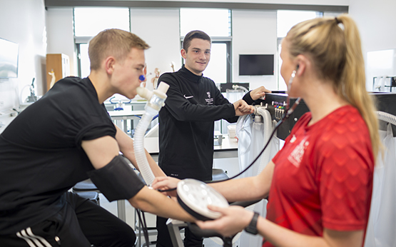 Students in sports science lab having VO2 max test on exercise bike