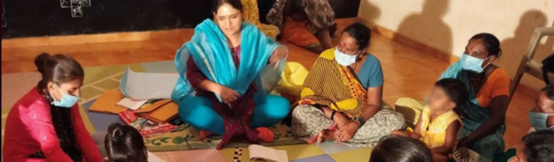 Women in India sitting in a circle on the floor