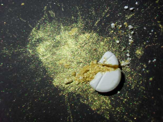 A pill surrounded by gold dust