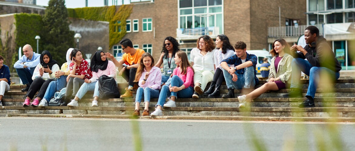 Students sitting on steps in front of Fulton House, Singleton Campus