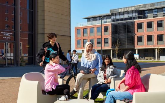 Students sitting on chairs in front of the great hall, Bay Campus