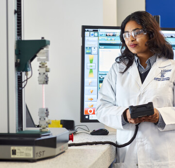 Biomedical student with tensile testing machine