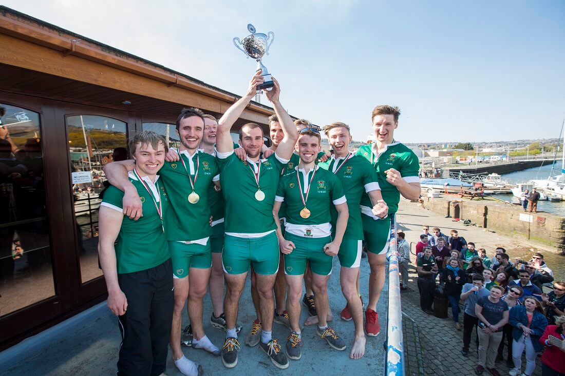 Rowing team holding up trophy 