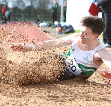 a student competing in the long jump at Varsity