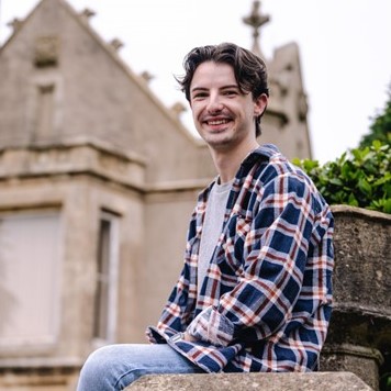 Tom sitting on a wall.