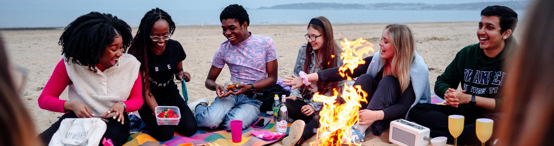 Four students on Bay Campus chatting near the bike hire stand.