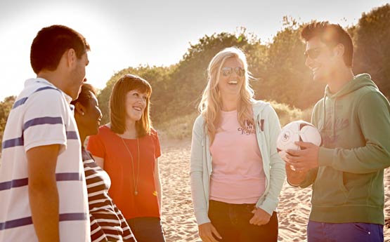 Students stood chatting in the sun at the beach