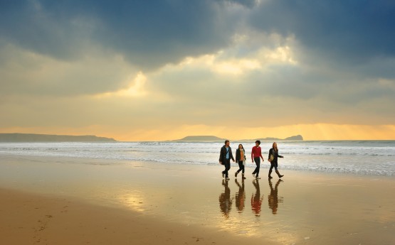 students walking along the beach