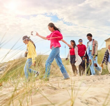 6 students walking along the beack