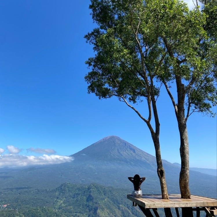 student sitting on high point in front of scenic view in Bali