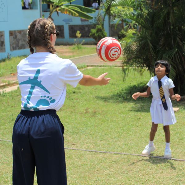 Student throwing a ball to a child