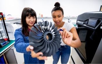 Two female students explore mechanical device