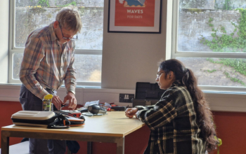 A repairer and an attendee at the repair café looking at an item for repair