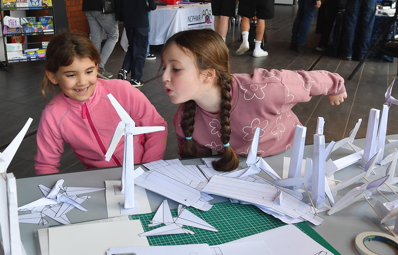 Two girls playing with the paper windmills