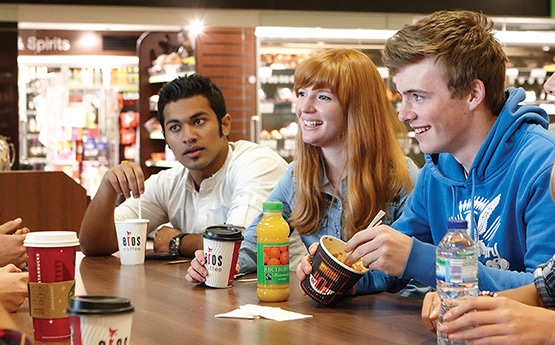 Students socialising around a canteen table.