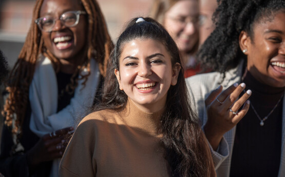 International student smiling with a group of friends.