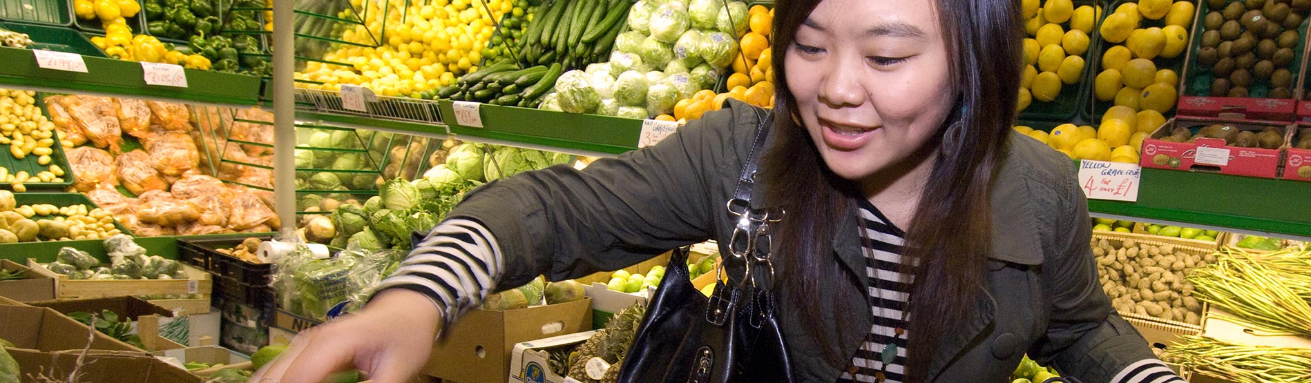 Student picking out vegetables in a supermarket.