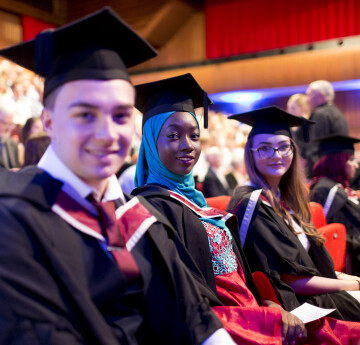 three students during graduation ceremony 