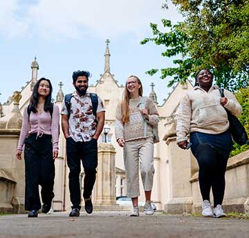 Swansea University students walking out of Singleton Campus from the Abbey towards the park, the Abbey building is visible in the background