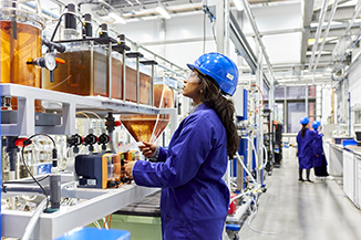 Student in Engineering lab with a blue coat on 