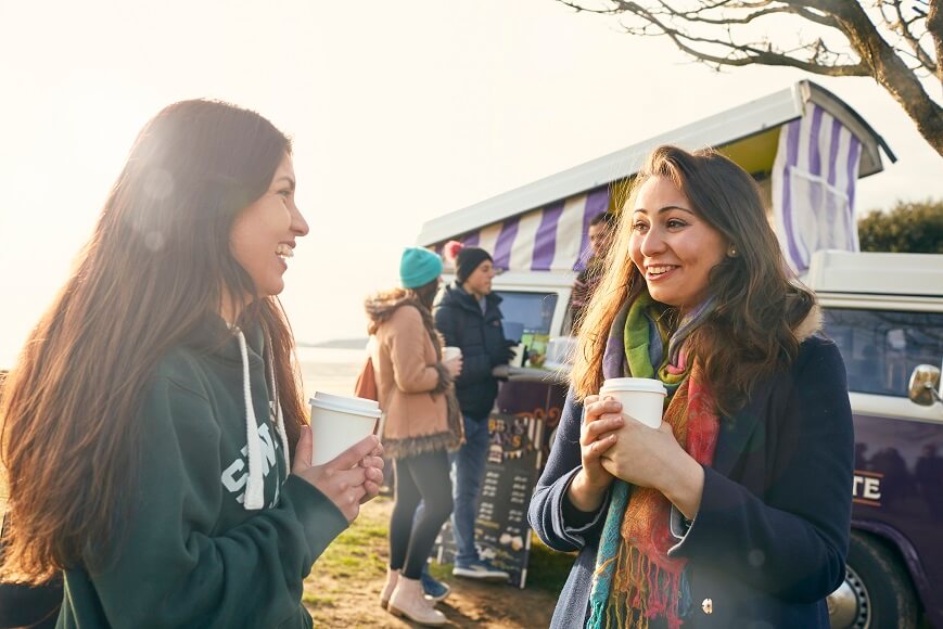 Students at the coffee campervan by the beach in winter