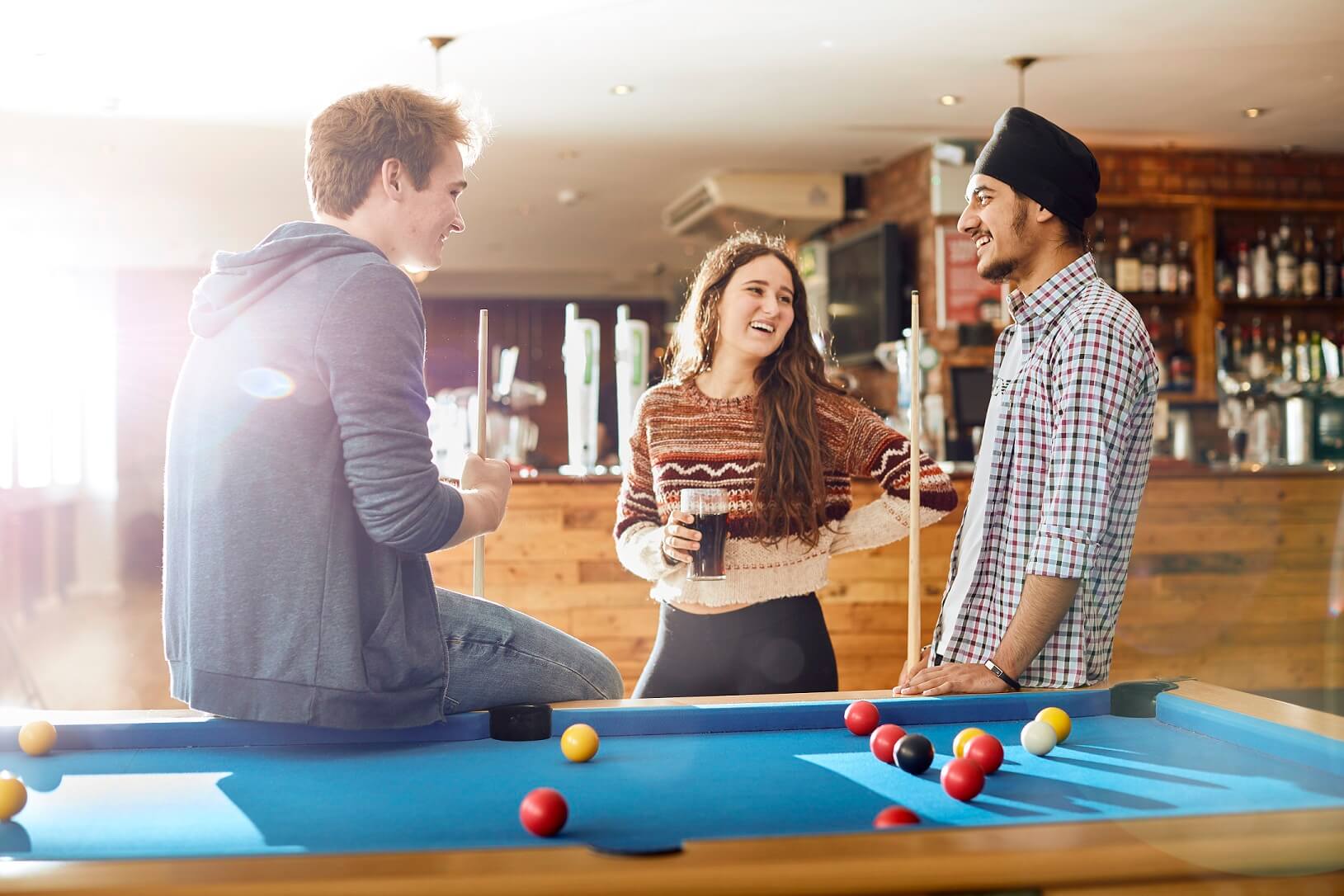 Students chatting around a pool table