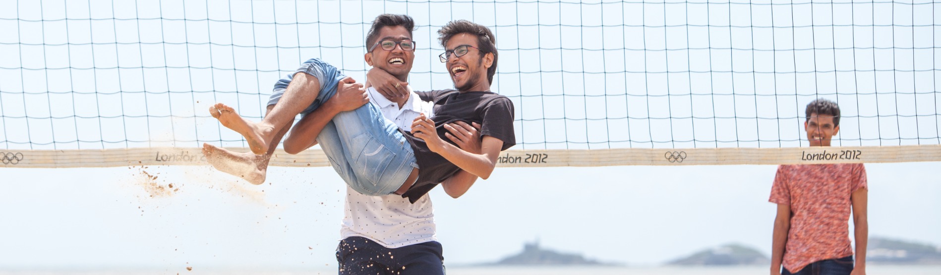2 International students celebrating at a beach volleyball game in Swansea