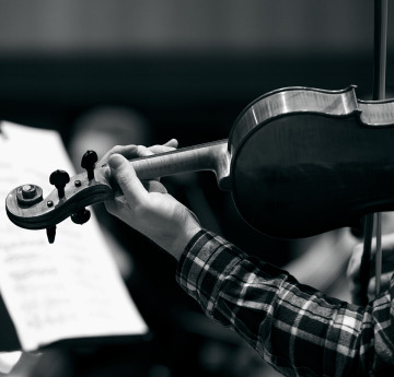 a black and white image of someone playing the violin