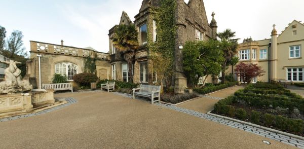 Courtyard garden with historic stone buildings, benches, and pathways