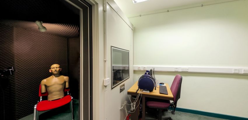 Audiology research booth with soundproof testing room and computer workstation
