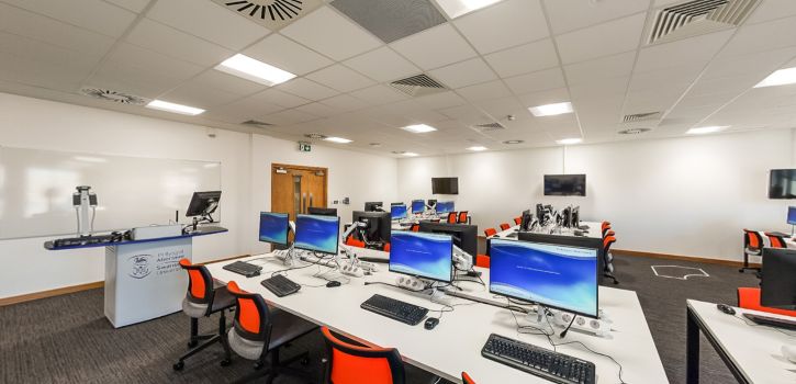 Computer lab with desktop workstations, teaching podium and collaborative learning space 