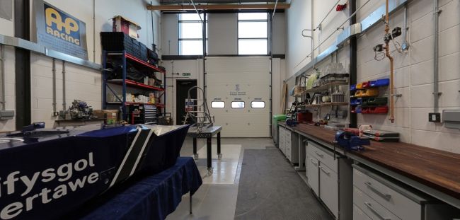 Formula Student workshop with race car parts, workbenches and tools