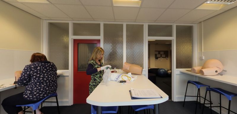 Midwifery skills lab with training models and students practising care