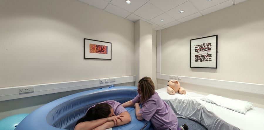 Normal birth room with birthing pool, hospital bed and training mannequin
