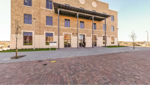 Exterior of a brick building with a covered entrance and paved walkway