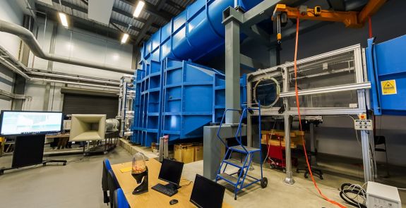 Engineering wind tunnel facility with testing equipment and large blue airflow chamber