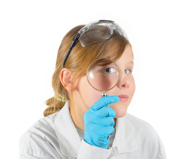 Girl dressed in lab coat with magnifying glass